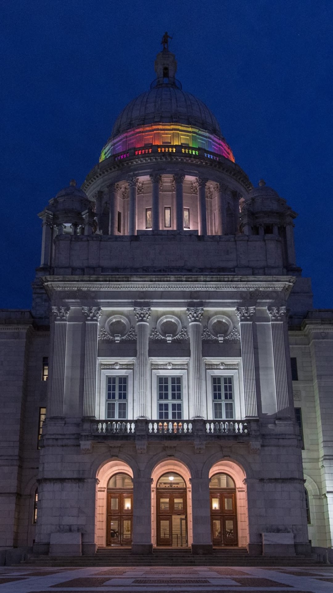 photo of RI Statehouse at night lit with rainbow lights