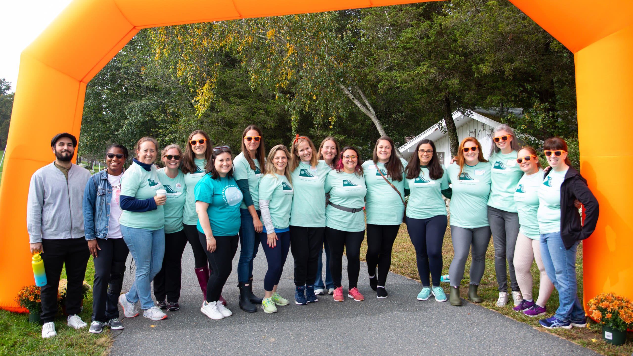 group photo of RNE Board, Staff, and Walk Committee members under the inflatable arch
